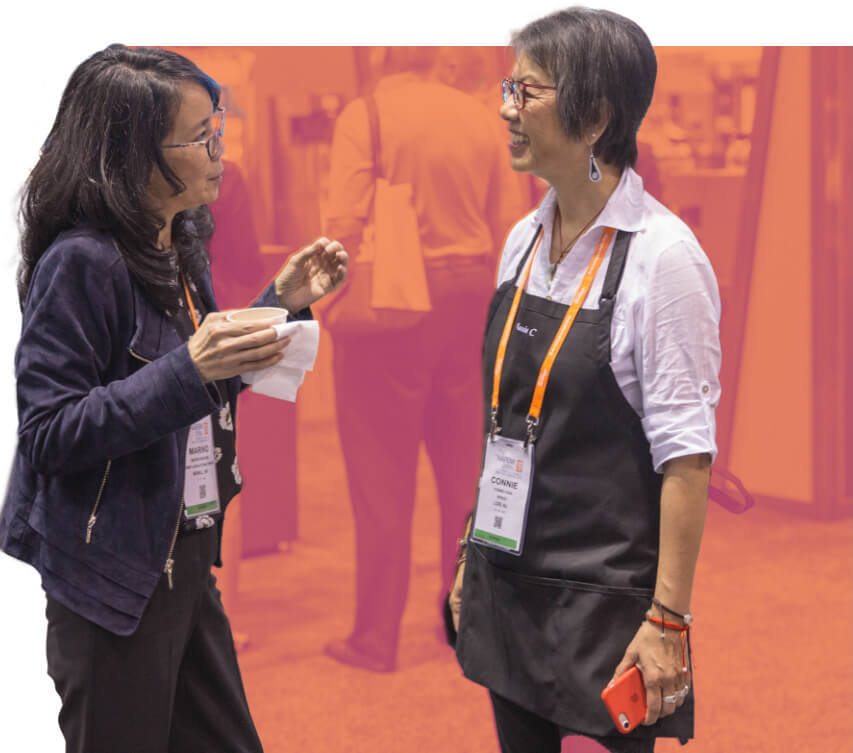 Two female attendees have a chat at The NAFEM Show.